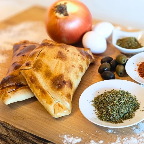 Empanadas de pino recién horneadas con cebolla, huevo, aceitunas y especias